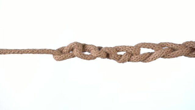 Untangling uncoupling knitted loops close up slow motion.