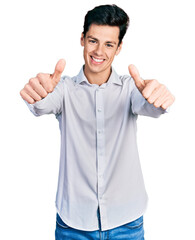 Young hispanic business man wearing business clothes approving doing positive gesture with hand,...