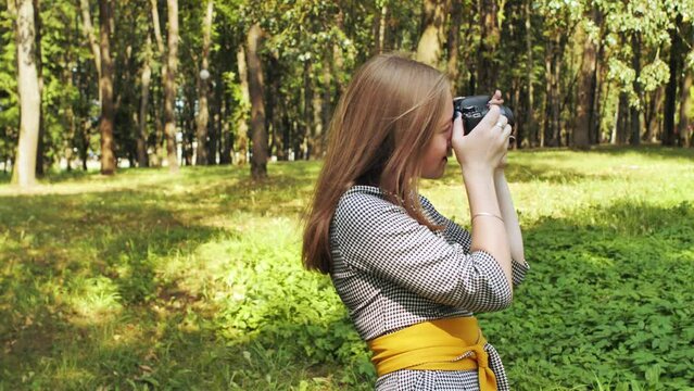 A girl taking pictures with her camera on a summer day.