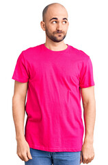 Fototapeta premium Young handsome man wearing casual t shirt smiling looking to the side and staring away thinking.