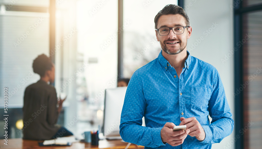 Poster i always work with technology in hand. portrait of a mature businessman standing in an office with c