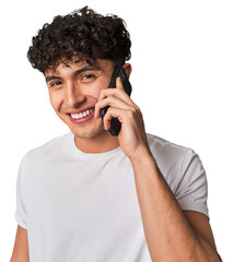 A young man talking on the phone, looking happy.