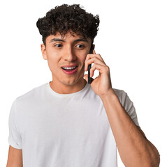 A young man talking on the phone, looking happy.