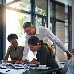 He loves the work his team does. Shot of a group of businesspeople having a meeting in a boardroom.