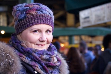 young woman smiling at the camera with market blurred in the background, portrait of a person