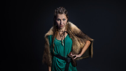 A Viking warrior woman in a fur cape. portrait on a black background