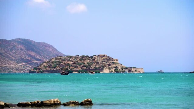 Spinalonga island, Crete, Greece. Tourists sail along the island in excursion boats. Spinalonga is the main local landmark.