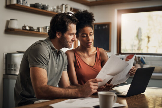 When Did This Happen. Cropped Shot Of An Affectionate Young Couple Going Through Paperwork While Doing Their Budget At Home.