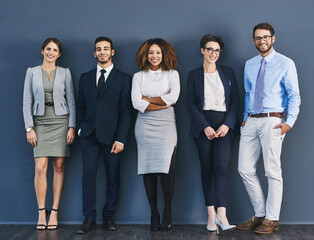 Surrounded by business minded individuals. Studio shot of a group of businesspeople standing in...