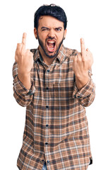 Young hispanic man wearing casual clothes showing middle finger doing fuck you bad expression, provocation and rude attitude. screaming excited