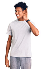 Young african american man wearing casual clothes smiling with hand over ear listening an hearing to rumor or gossip. deafness concept.