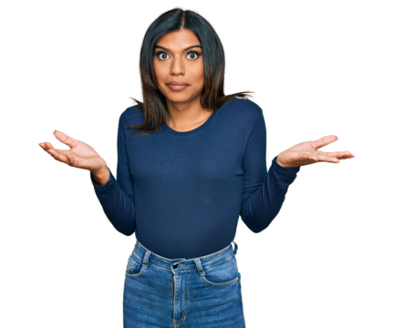Young latin transsexual transgender woman wearing casual clothes clueless and confused expression with arms and hands raised. doubt concept.