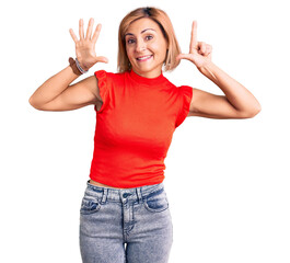 Young blonde woman wearing casual clothes showing and pointing up with fingers number seven while smiling confident and happy.