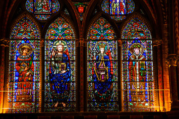 Stained glass windows with Jesus, Virgin Mary and apostles at Cahors Cathedral. Cahors, France. Cahors Cathedral is one of the French sites on Routes of Santiago de Compostela.  - obrazy, fototapety, plakaty