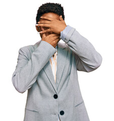 Young african american woman wearing business clothes covering eyes and mouth with hands, surprised and shocked. hiding emotion