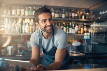 Business is right where he wants it. Shot of a young man using a digital tablet while working...