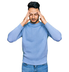 Naklejka premium Young arab man wearing casual clothes suffering from headache desperate and stressed because pain and migraine. hands on head.