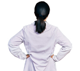 Young chinese woman wearing doctor uniform and stethoscope standing backwards looking away with arms on body