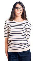 Fototapeta premium Brunette teenager girl wearing casual clothes and glasses winking looking at the camera with sexy expression, cheerful and happy face.