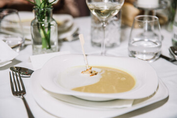 Creamy pumpkin soup with cream sauce and grilled shrimp, restaurant concept, celebration
