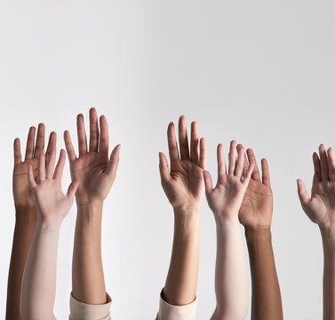 Making their voices heard. Shot of a diverse group of unidentifiable people holding their hands up against a white background.