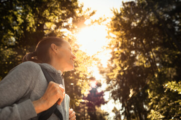 Happy young female hiking in the forest 