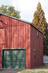 Fototapeta na wymiar The red barn has green garage doors.
