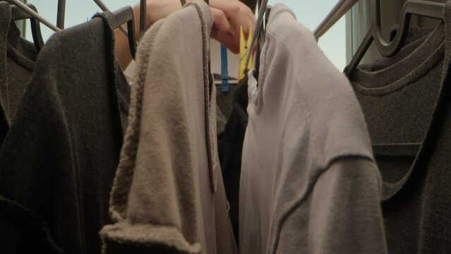 vue originale et macro d'un homme qui enl&egrave;ve des chaussettes d'un &eacute;tendoir &agrave; linge