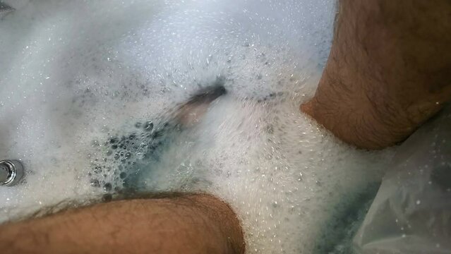 Close up human foot while stand in rapid water stream, hydrotherapy holiday concept