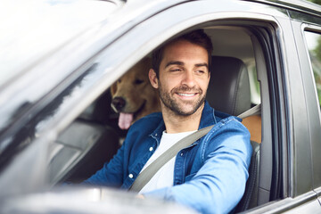Looks like were here, boy. Cropped shot of a handsome young man taking a drive with his dog in the backseat.