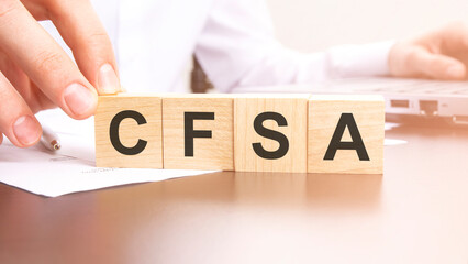 man made text CFSA with wood blocks on the background of the office table. selective focus. business concept.
