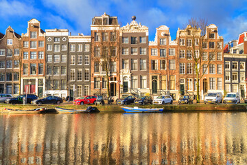 Cityscape on a sunny winter day - view of the houses and the city canal with boats in the historic...