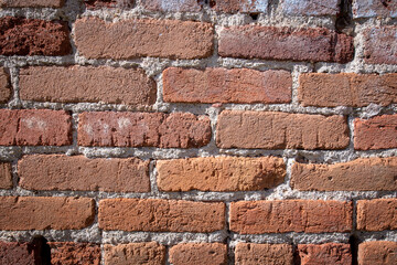 An old brick wall showing a weathered history which can be used as a background