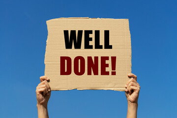 Well done message on box paper held by 2 hands with isolated blue sky background. This message...