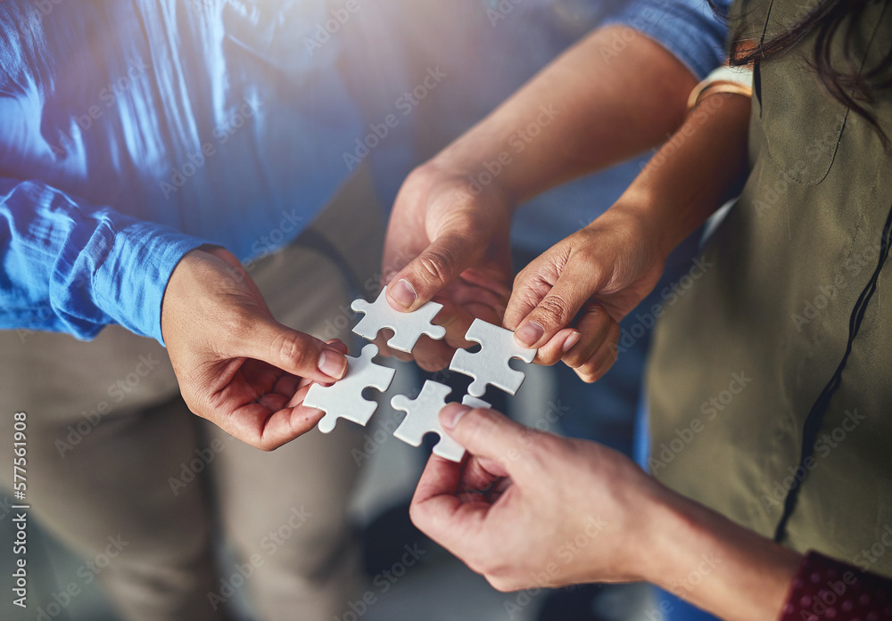 Poster finding the right solutions as a team. shot of a team of businesspeople putting puzzle pieces togeth