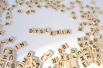 closeup wooden alphabet blocks, DYSLEXIA word on white background, dyslexia awareness, learning...