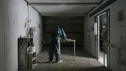 Worker polishes board before painting. Creative. Worker in suit grinds board in special room....