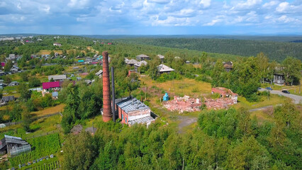 Fototapeta na wymiar Top view of ruins of old factory in village. Clip. Collapsed building of brick factory in village in summer. Ruins of old brick factory in village