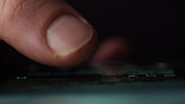 Macro shot of a finger doom scrolling social media or browsing internet. Front view with reflection on glass