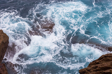Fototapeta na wymiar Crazy storm is crashing the rocks in Atlantic Ocean making beautiful mix of aquatic blue, green, deep blue and other colors 