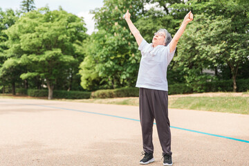 公園で運動・体操・ストレッチする高齢者女性
