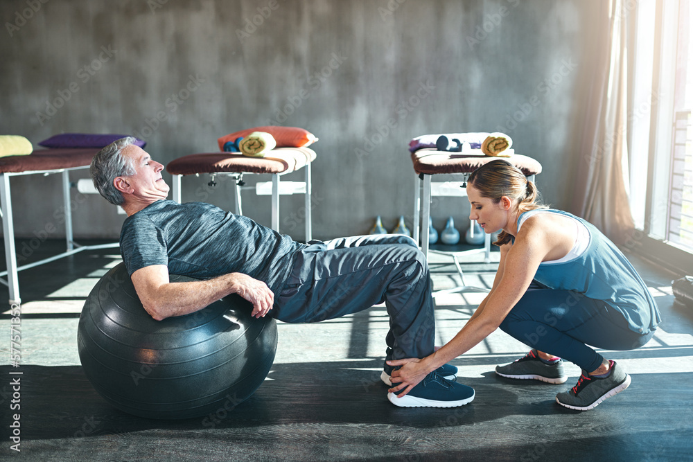 Poster Time to get up and get moving. Shot of a senior man working out with his physiotherapist.