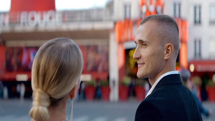 Walking cute couple. Action. A beautiful woman on the street looks at her cute adult partner.