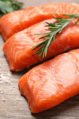 Fresh salmon and ingredients for marinade on wooden table, closeup