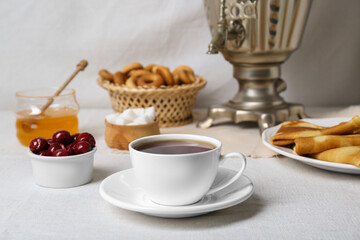 Aromatic tea, traditional Russian samovar and treats on table
