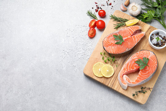 Fresh salmon and ingredients for marinade on light grey table, flat lay. Space for text