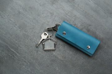 Leather case with keys on grey table, top view. Space for text