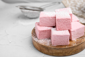 Tasty marshmallows with powder sugar on white textured table, closeup. Space for text