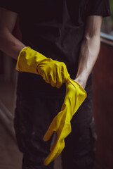 Caucasian male builder wears yellow gloves.