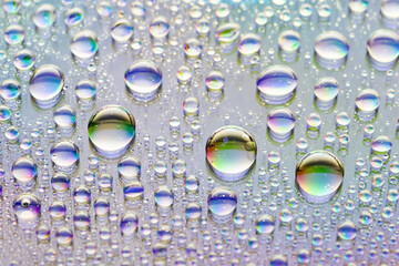 Water drops. Abstract background. Macro texture of a lot of drops. Rainbow color gradient. Heavily textured image. Shallow depth of field. Selective focus